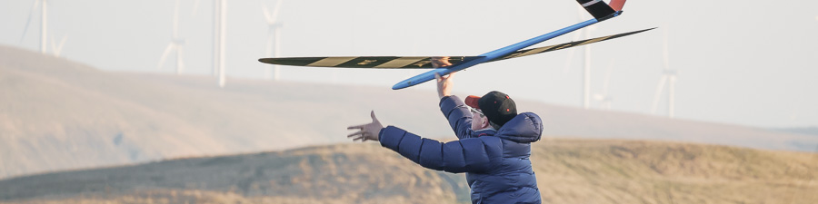 RC glider with background of wind turbines