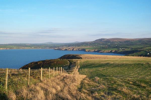 Dinas Island cliffs are 450 ft at highest point, with steep slopes. Purrfect.